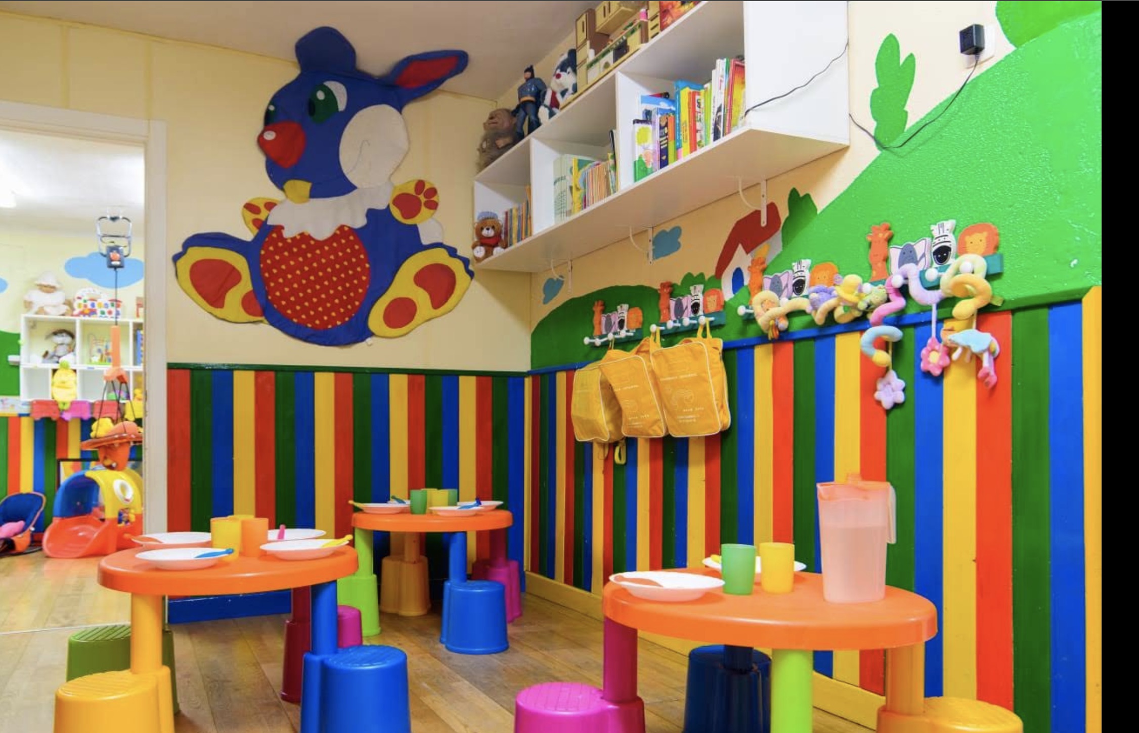 Aula con mesas infantiles y decoración de colores